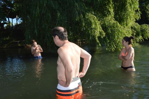 a group of people standing in the water at Coyunche Cabañas y Camping Laja & San Rosendo in Laja