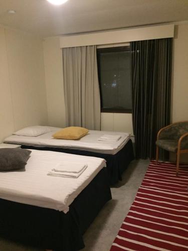 a hotel room with two beds and a window at Mänty Holiday Apartments in Rovaniemi