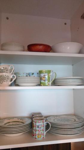 a shelf filled with plates and cups and dishes at Apartment Evergreen Bovec in Bovec