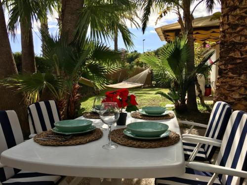a white table with green plates and glasses on it at Royal Garden Santa Clara in Jávea