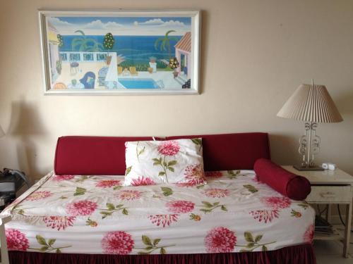 sypialnia z łóżkiem z różowymi kwiatami w obiekcie Montego Bay Club-Delux Seaside condo w mieście Montego Bay