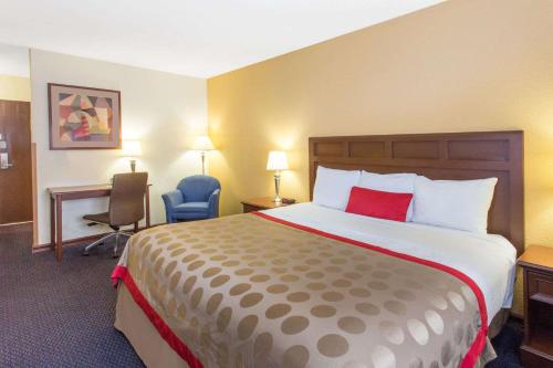 a hotel room with a large bed and a desk at Baymont by Wyndham Waukesha in Waukesha