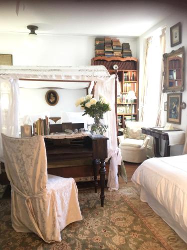 a bedroom with a bed and a table with a piano at Church Des Artistes in Kingston