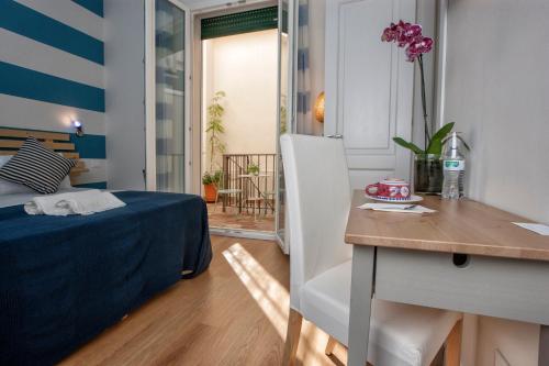 a room with a bed and a desk and a table at B&B Kalavrìa in Reggio Calabria