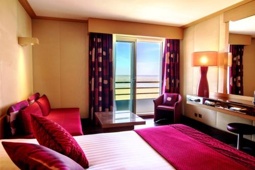 サン・ブルヴァン・レ・パンにあるHôtel Spa du Beryl Joaのベッドと大きな窓が備わるホテルルームです。