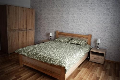 a bedroom with a bed and two night stands with lamps at Baltic coast Apartments in Liepāja