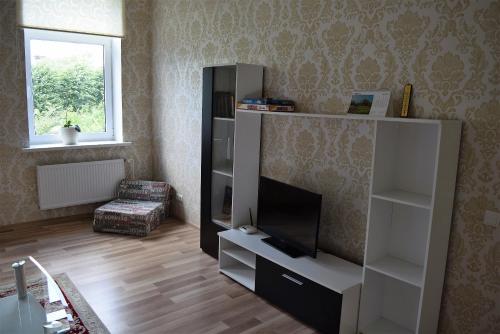 a living room with a entertainment center with a flat screen tv at Baltic coast Apartments in Liepāja