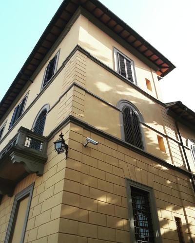 a tall brick building with windows and a balcony at Villa Socini in Siena