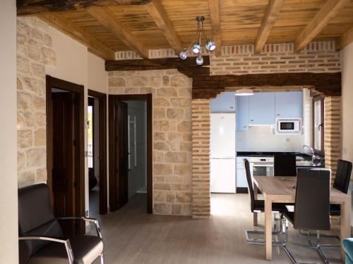a kitchen and dining room with a table and chairs at Apartamentos La Fabrica in Villaluenga de la Vega