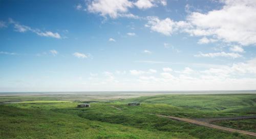 a green field with two buildings in the middle at Hrifunes Nature Park in Hrífunes 