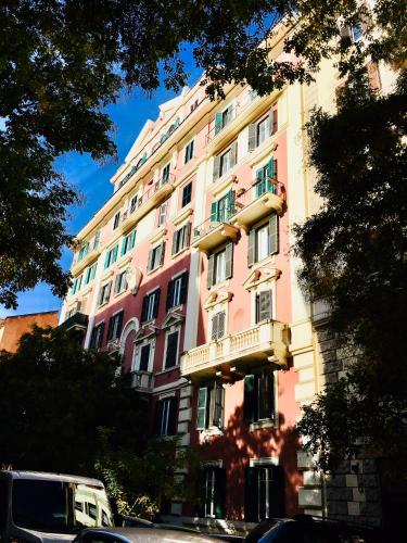 a pink building with a balcony on the side of it at RHH Rome Holiday Home in Rome