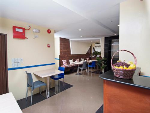 a restaurant with tables and chairs and a basket of fruit on a counter at Skyblue Hotel in Cebu City