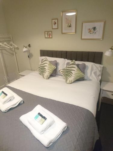 a bedroom with a bed with two towels on it at The Milford Arms in Hounslow