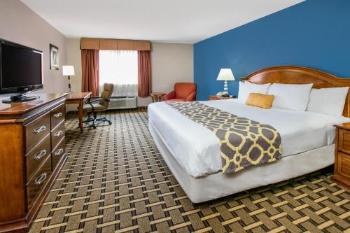 a hotel room with a bed and a flat screen tv at Baymont by Wyndham Lawton in Lawton