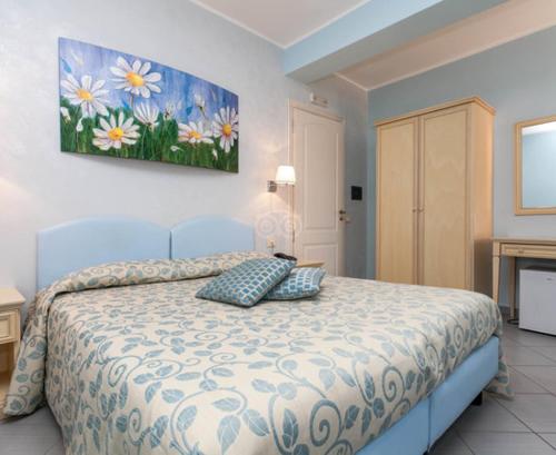 1 dormitorio con 1 cama con una pintura en la pared en Villa Aurora, en Le Castella