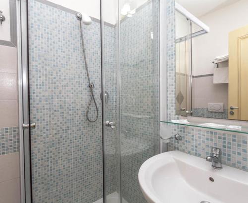 a bathroom with a glass shower and a sink at Villa Aurora in Le Castella