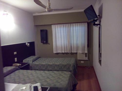 um quarto de hotel com duas camas e uma janela em Petit Hotel em Chivilcoy