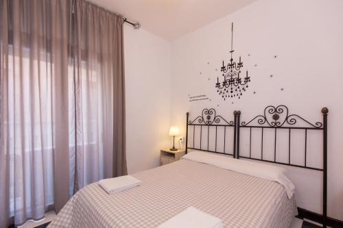 a bedroom with a bed and a chandelier at Pension Mesones in Granada