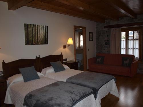 a bedroom with two beds and a couch at Hotel Ço De Pierra in Betrén