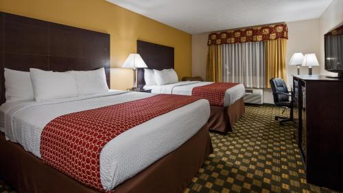 a hotel room with two beds and a desk at Best Western Paris Inn in Paris