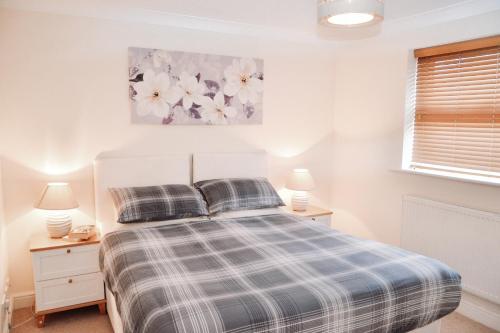 a bedroom with a bed and two lamps and a window at Blackwater Meadow Apartment in Ellesmere