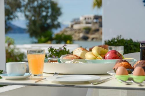 a table with a plate of food and a bowl of fruit at Thomais Studios in Naxos Chora