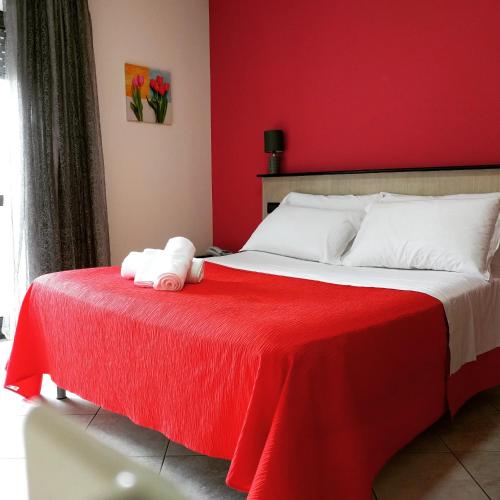 a red bedroom with a bed with a red blanket at Hotel Le Ceramiche in Montalto Uffugo