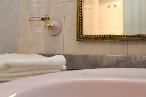 a bathroom with a white tub and a mirror and towels at San Anton in Cáceres
