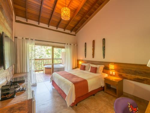 a bedroom with a bed and a tv and a balcony at Kalango Hotel Boutique in Ilhabela