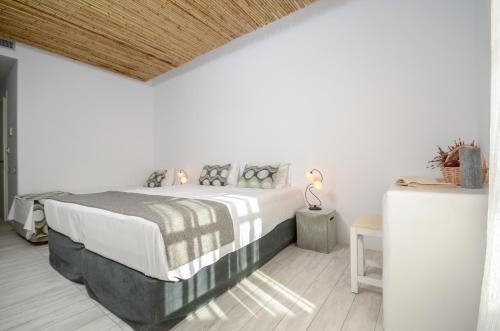 a bedroom with a large bed with a wooden ceiling at Thomais Studios in Naxos Chora