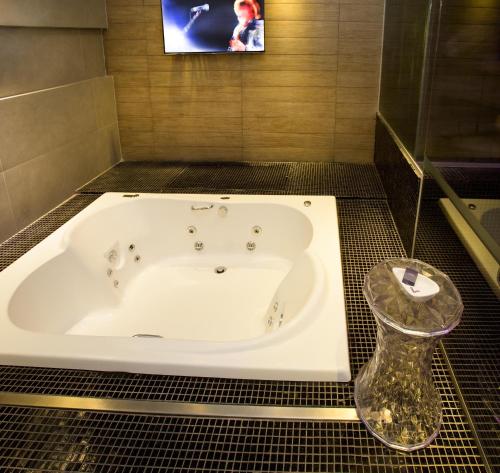 a bath tub in a bathroom with a tv at Lush Motel Ipiranga in Sao Paulo