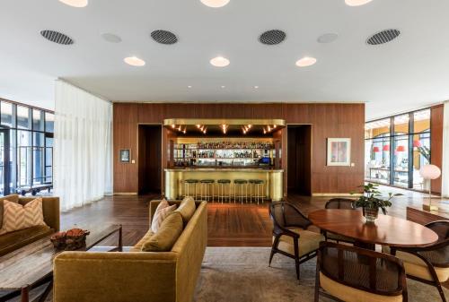 a living room with a bar in the background at The Dewberry Charleston in Charleston