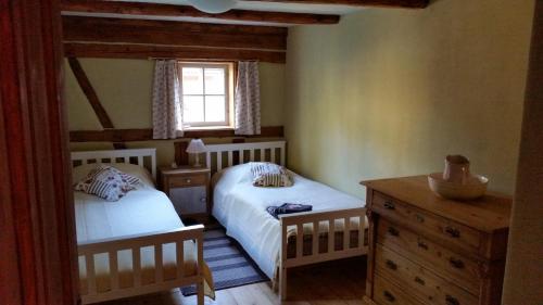 een slaapkamer met 2 bedden, een raam en een dressoir bij Am Waldessaum in Kurort Oybin