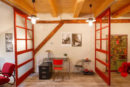 a room with a red chair and a desk in it at Hotel & Depandance Kopacka in Lanškroun