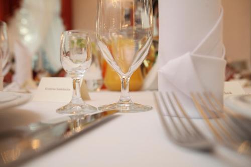 two wine glasses sitting on top of a table at Hotel Jakub Sobieski in Oława