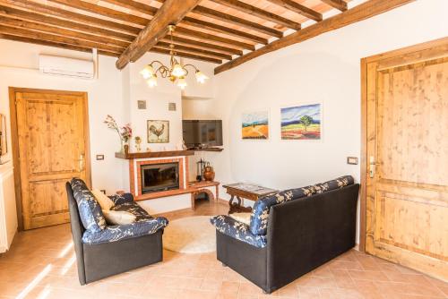 a living room with two chairs and a fireplace at Agriturismo Cantagalli in San Quirico dʼOrcia