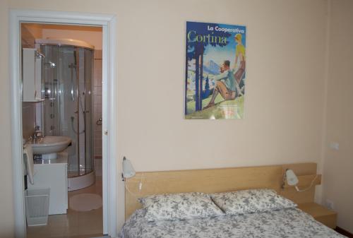 Nervesa della BattagliaにあるAgrifoglio B&Bのベッドルーム1室(ベッド1台付)、壁にポスターが備わります。