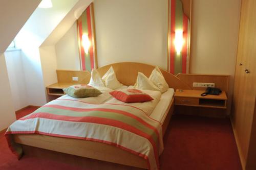 a bedroom with a large bed with two pillows at Hotel Restaurant JUWEL in Gaflenz