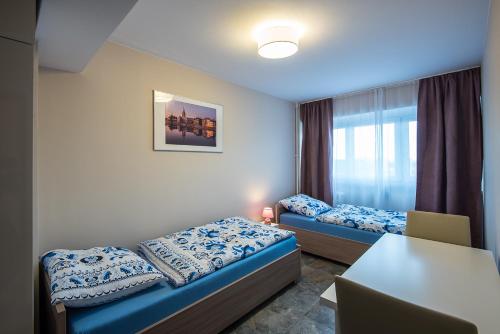 a small room with two beds and a table at City On Foot in Wrocław