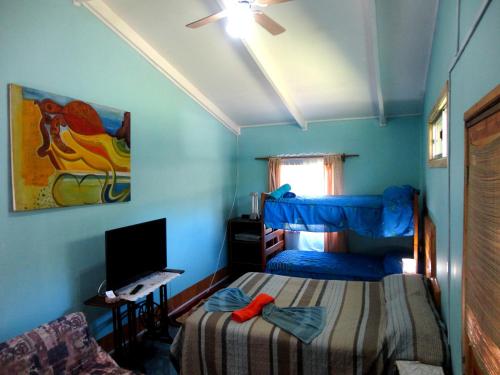 a bedroom with a bed and a desk with a computer at Cabañas Akiko in Hanga Roa