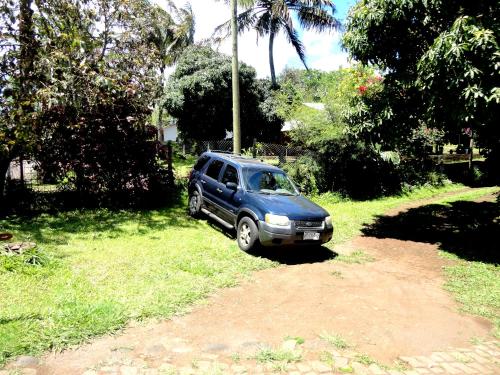 a blue suv parked on the side of a dirt road at Cabañas Akiko in Hanga Roa