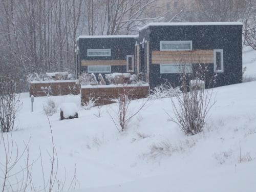 a snow covered yard with a building in the background at Camping-Hotel de Plein Air Les 2 Bois in Baratier