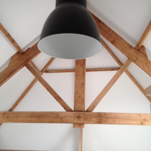 a light hanging from a ceiling with wooden beams at Vakantiewoning Margaux -free parking - Sauna in Bruges