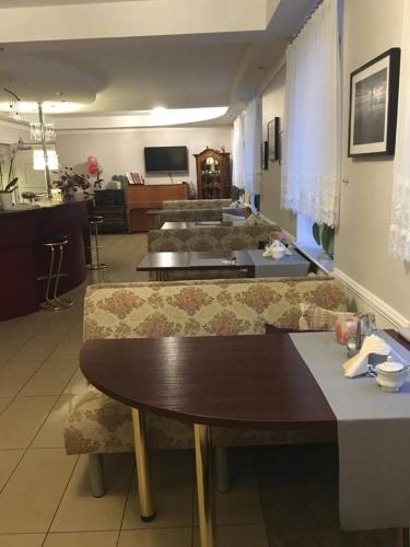 a living room with a table and chairs and a room at Koral in Koszalin