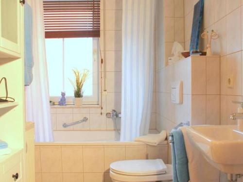 een badkamer met een bad, een toilet en een wastafel bij Exklusive Ferienwohnung an der Elbe in Dresden