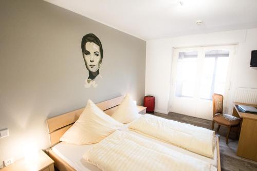 a bedroom with a bed with a painting on the wall at Hotel Rave in Velen