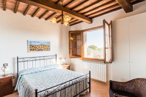 a bedroom with a bed and a window at Agriturismo Cantagalli in San Quirico dʼOrcia