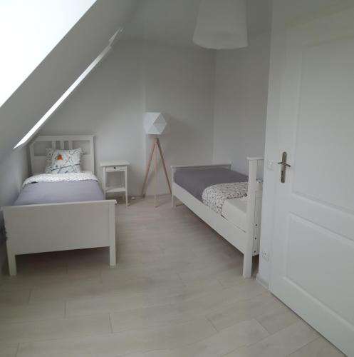 1 dormitorio con 2 camas y escalera en Wysokie Łąki domki w górach en Kowary