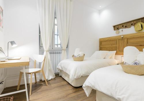 sypialnia z 2 łóżkami, stołem i biurkiem w obiekcie Madrid Center, Apartamento de 2 dormitorios w Madrycie