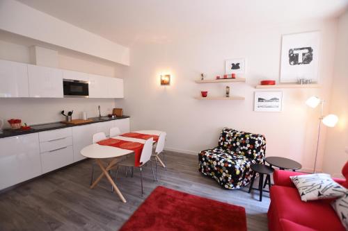 a living room with a red couch and a kitchen at Le Rondinelle in Como